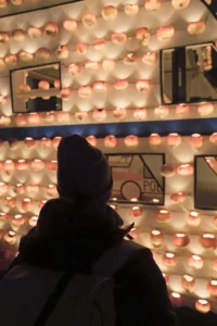 Person blickt auf eine grosse, mit hunderten Räbeliechtli bedeckte Fassade der Räbechilbi Richterswil 2025