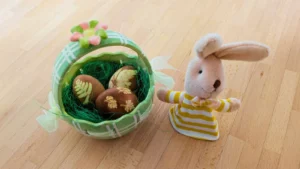 Grüner Osterkorb mit natürlich gefärbten Eiern und Plüschhase