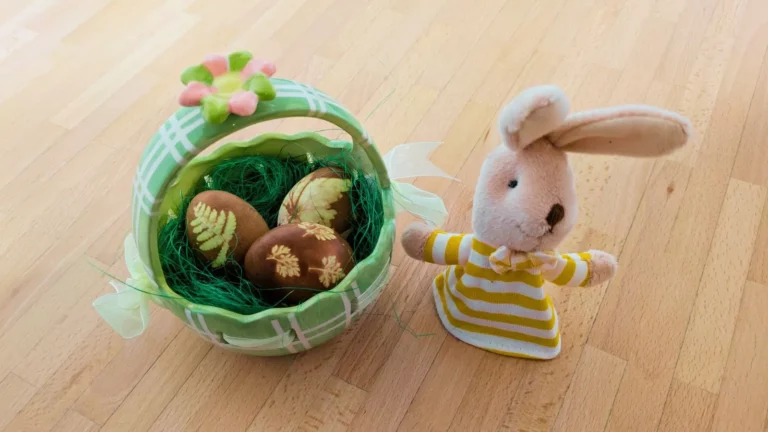 Grüner Osterkorb mit natürlich gefärbten Eiern und Plüschhase