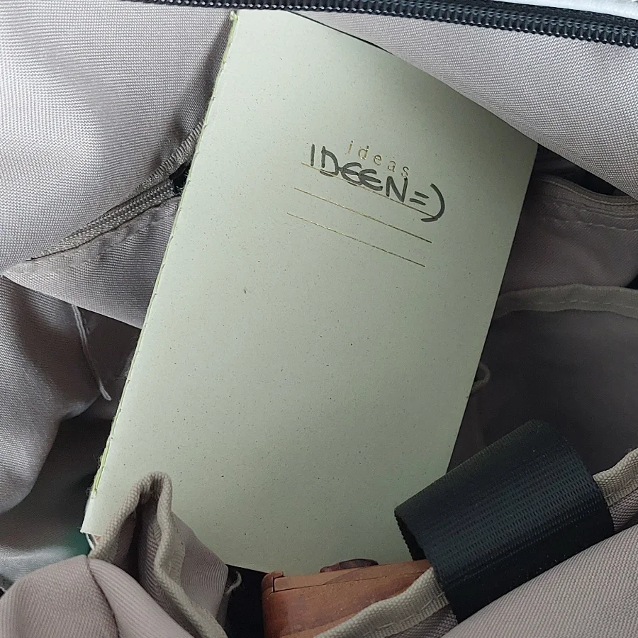 Handliches Notizheft für Ideen und Brainstorming unterwegs, verstaut in einer Tasche.